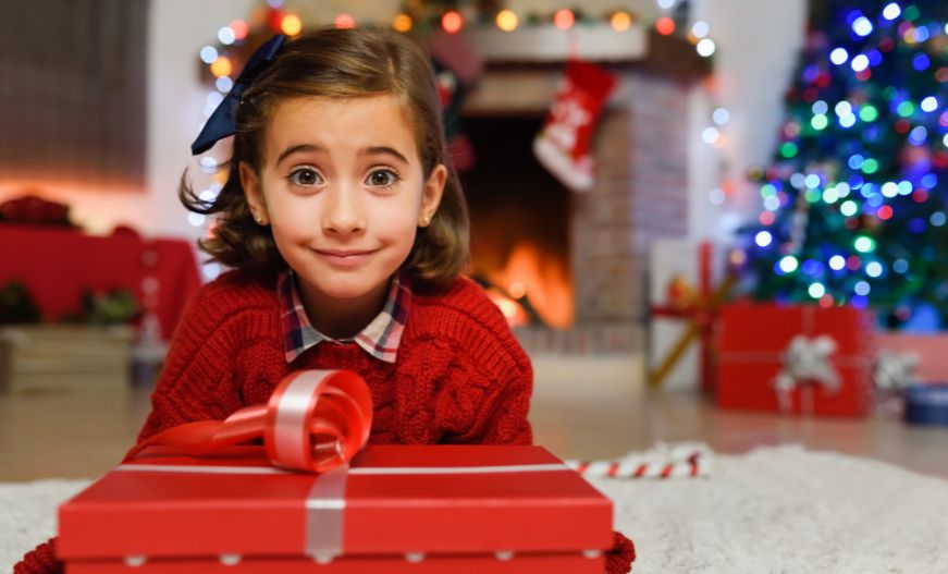 A kid with a gift and ready to Perform Christmas Celebration In Preschool