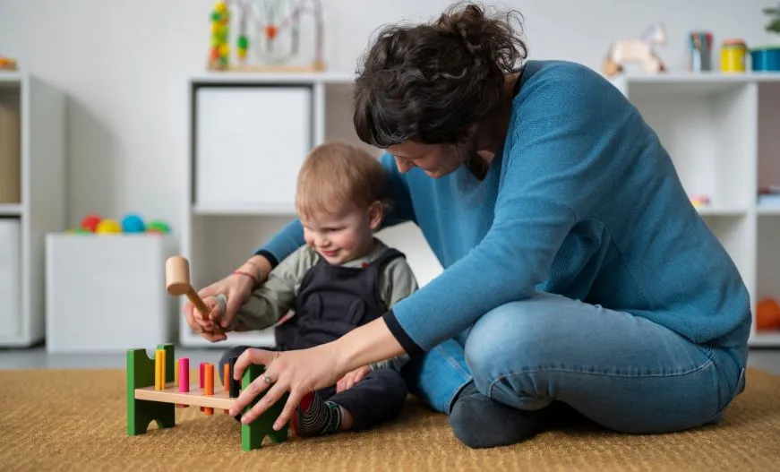 A female teacher guiding a kid on cognitive toys